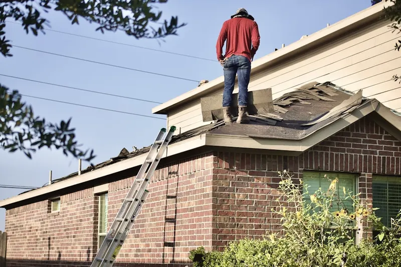 Professional roofer working on a residential roof in Military Park